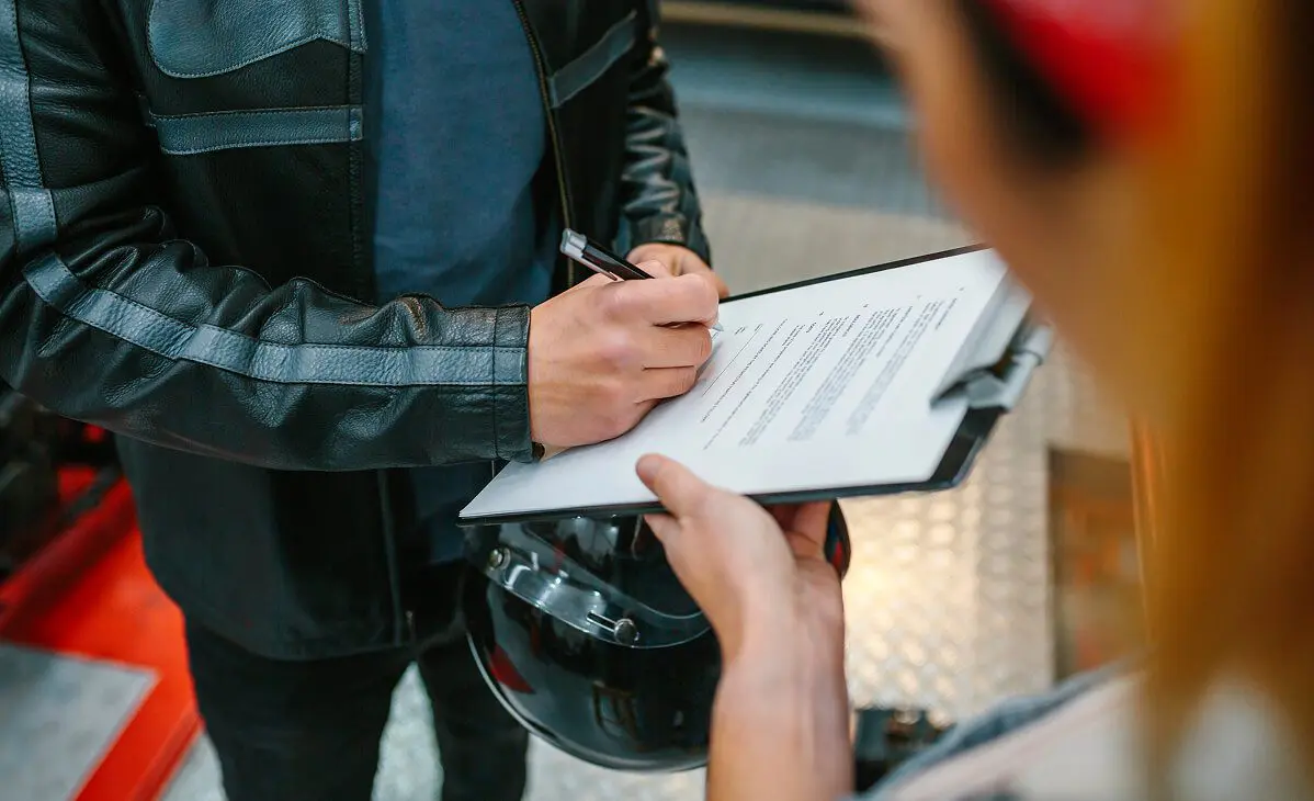 Person holding a helmet and signing form