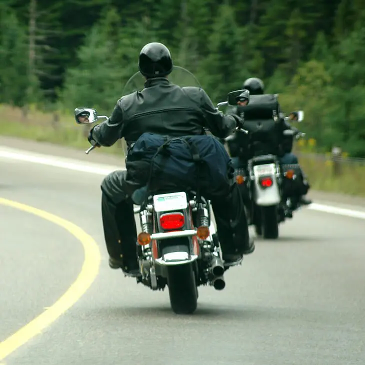 Bikers cruising through forested highway